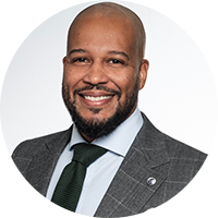 older black man wearing a checkered suit with a black tie